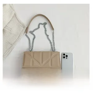 Beige quilted chain crossbody bag shown next to a smartphone for size reference