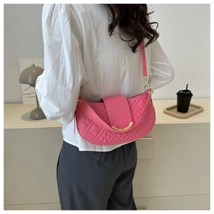 Detailopname van roze gewatteerde crossbodytas met gouden metalen gespversiering