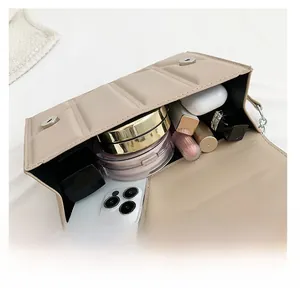 Top view of khaki crossbody bag interior showing storage space for phone and makeup