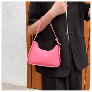 Detail of pink hobo underarm bag with zipper closure shown on a black suit jacket