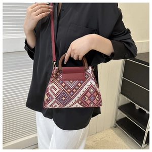 Close-up of vintage jacquard handbag with geometric patterns and wooden circular handles