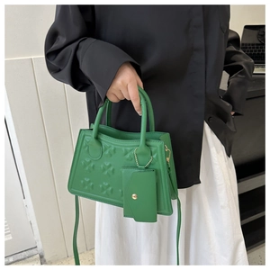 Detail van klaverbladreliëf op groene PU-leren schoudertas met extra klein afneembaar tasje