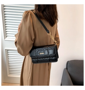 Detail achteraanzicht van zwarte gewatteerde crossbodytas met gouden ketting en riem