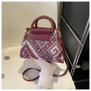 Detailed weave of geometric diamond pattern on ethnic canvas bag with wooden handle