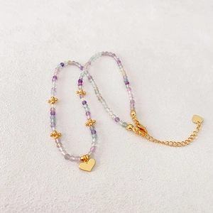 Collier de perles pastel violettes et vertes avec pendentif coeur en or