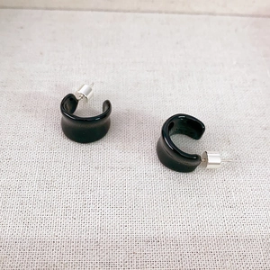 Elegant C-shaped black enamel hoop earrings with 925 silver needle on textured beige linen
