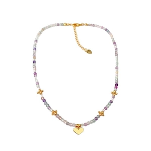 Collier de perles tendance avec pierres violettes et pendentif cœur doré sur fond blanc