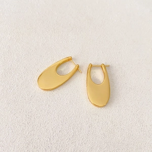 Macro view of French vintage U-shaped earrings in polished 18K gold plated copper metal
