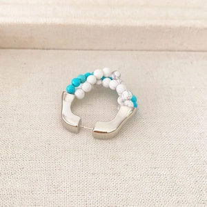 Vintage turquoise beaded hoop earrings with silver-plated base on textured fabric