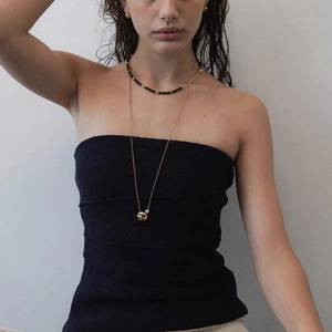 Minimalist gold and silver layered necklace set with beaded accents on a female model