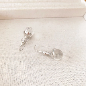 Elegant silver waterdrop hook earrings with clear crystal glass balls on white texture