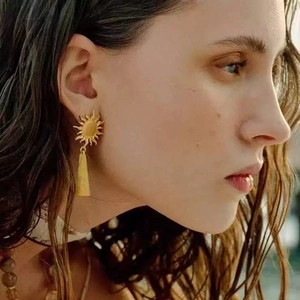 French vintage sunflower tassel earrings in gold finish worn by model in warm light