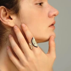Irregular silver textured ring with black bead inlay shown on model in a soft lighting