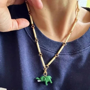 Close-up of handmade enamel elephant pendant with unique gold and ivory beaded chain