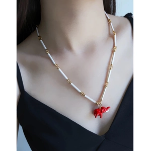 Close-up of red elephant pendant necklace with white bamboo chain on model