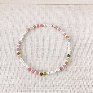 Fashionable colorful gemstone beaded bracelet with silver metal spacers on canvas