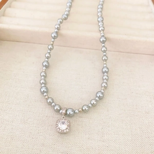 Detail of grey pearl necklace with a square cubic zirconia pendant on jewelry box