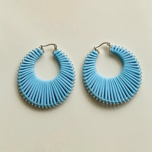 Detail of blue cord-wrapped hoop earrings with silver beaded trim in Bohemian style