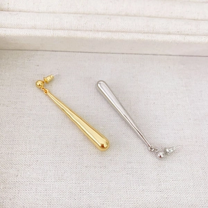 Minimalist teardrop dangle earrings in gold and silver finish on a textured background