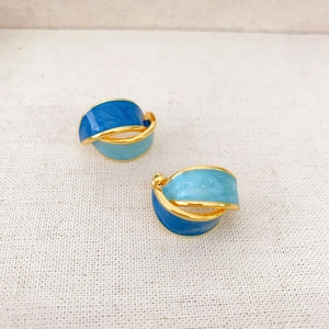 Retro C-shape gold-plated earrings with blue Morandi enamel inlay on fabric background
