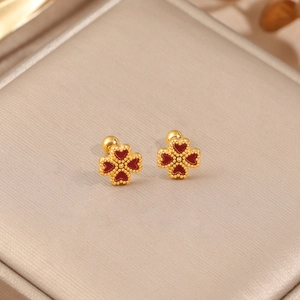 Boucles d'oreilles trèfle en or avec pétales de cœur rouges sur fond de soie