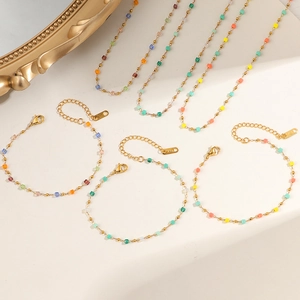 K18 gold chain necklace set featuring colorful crystal beads on a textured surface