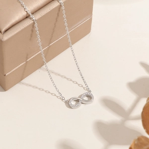 Infinity heart pendant necklace with shimmering zircon stones on a dainty silver chain
