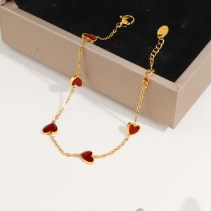 Golden titanium steel bracelet featuring five red heart charms and lobster clasp closure