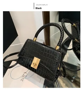 Macro detail of glossy black crocodile embossed leather with a gold twist-lock buckle