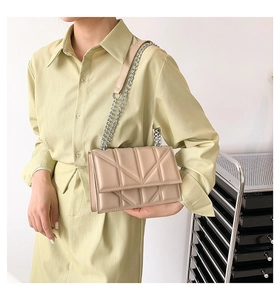 Detail of beige chain shoulder bag with geometric X quilting on premium leather