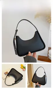 Detail of a black hobo shoulder bag with matte leather texture and gold hardware