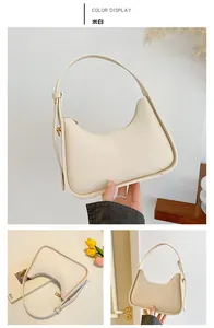 Detail view of cream saddle shoulder bag with wide strap and golden hardware accents