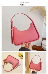 Detail view of a pink crescent underarm bag with smooth finish and adjustable shoulder strap