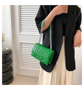 Chic green quilted shoulder bag with silver chain strap worn with stylish outfit