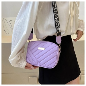 Detail of lavender quilted crossbody bag with adjustable wide jacquard strap and metal logo