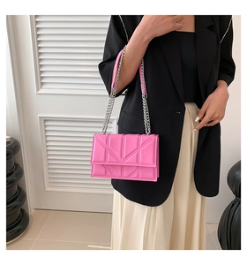 Fashionable bright pink quilted chain bag shown on model with elegant geometric stitching