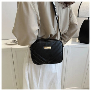 Black quilted crossbody camera bag with wide letter strap and gold plate detail