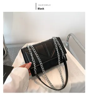 Detail of black quilted leather shoulder bag with V-shaped texture and silver chain