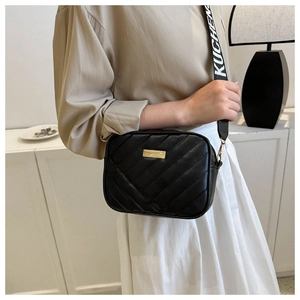 Quilted black crossbody camera bag with gold hardware and a wide jacquard strap