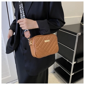 Caramel brown quilted PU leather crossbody bag with patterned shoulder strap on model