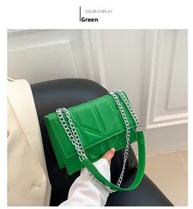 Detailed close-up of a green chain crossbody bag with V-shaped geometric stitching