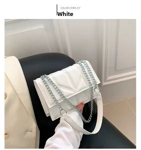 Detail of white chain bag featuring V-shaped quilting and silver metal hardware