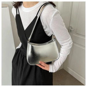Detail view of fashion silver mirror shoulder bag with FASHION & BAGS text on surface