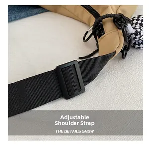 Détail de la bandoulière réglable noire sur un sac cabas en toile de couleur kaki