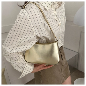 Detail of a shiny metallic gold hobo bag featuring fashion text print and sleek strap