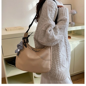 Détail du sac fourre-tout en nylon beige avec bandoulière et pendentif à damier