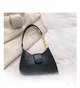 Détail du sac croissant en cuir noir avec chaîne dorée et bandoulière en cuir chic