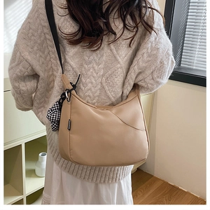 Détail du sac croissant en nylon kaki avec son pendentif peluche à damier sur modèle
