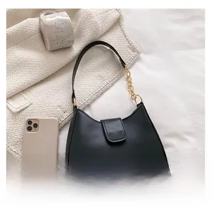 Détail du sac à main croissant noir mat avec une élégante bandoulière en chaîne dorée