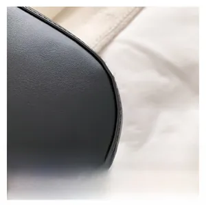 Détail macro du sac à main en cuir grainé noir avec des coutures précises